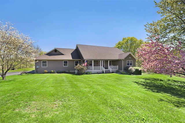 rear view of house featuring a lawn and a porch
