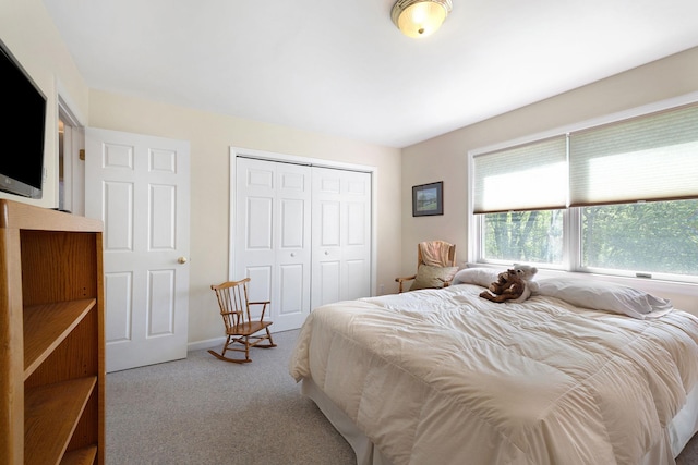 carpeted bedroom featuring baseboards and a closet