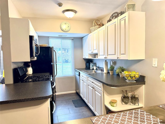 23 Kiowa Ct Unit 23, Coram, NY 11727 - kitchen with dark countertops, a sink, stainless steel appliances, white cabinetry, and dark tile patterned floors
