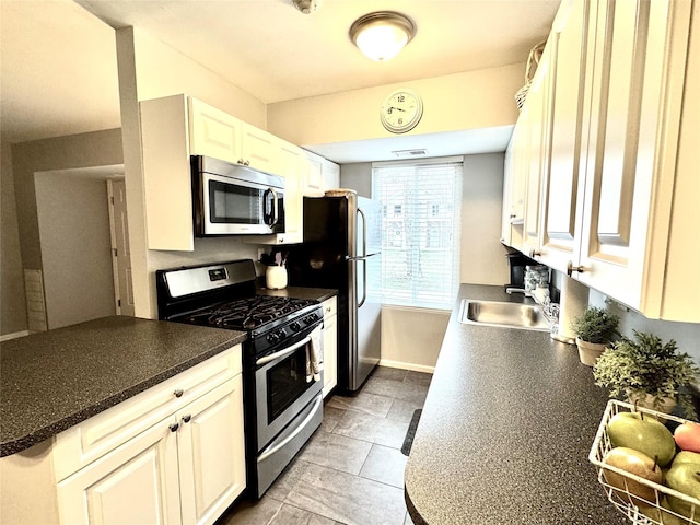 23 Kiowa Ct Unit 23, Coram, NY 11727 - kitchen with dark countertops, appliances with stainless steel finishes, baseboards, and a sink