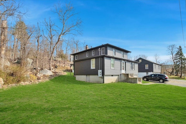 view of side of property featuring a lawn and a chimney