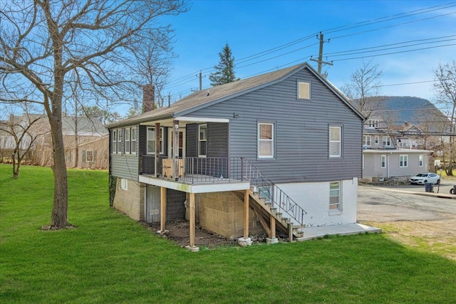 back of house with a lawn, a chimney, stairs, and a deck