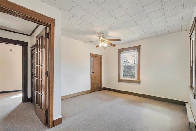 unfurnished room with ceiling fan, baseboards, and carpet flooring