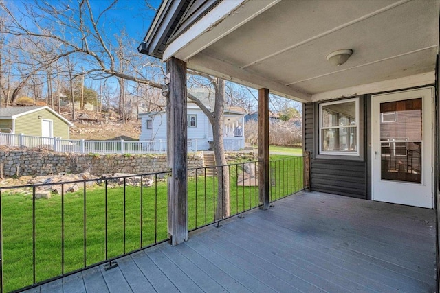 wooden terrace featuring a lawn and fence