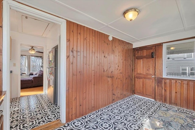 empty room featuring attic access and wooden walls