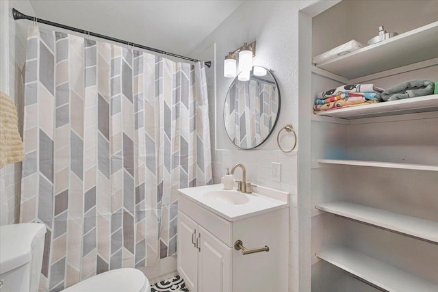 full bath featuring tile walls, toilet, and vanity