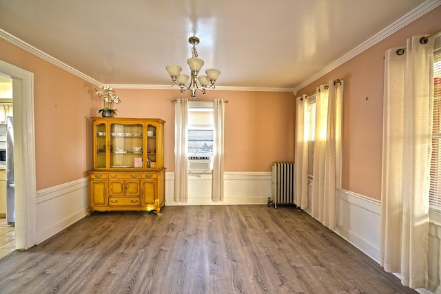 9249 Springfield Blvd, Queens Village, NY 11428 - unfurnished dining area with radiator, a chandelier, wood finished floors, ornamental molding, and wainscoting