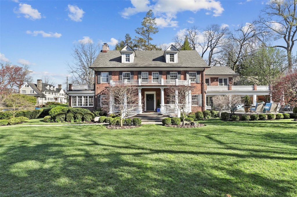 530 Monterey Ave, Pelham, NY 10803 - view of front of house featuring covered porch, brick siding, a front yard, a balcony, and a chimney