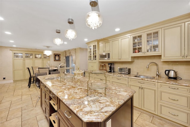 kitchen with a sink, cream cabinets, and stainless steel microwave