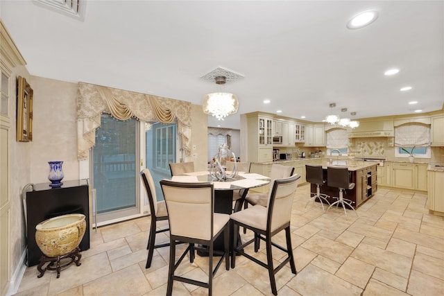dining area featuring stone finish flooring, recessed lighting, and a chandelier