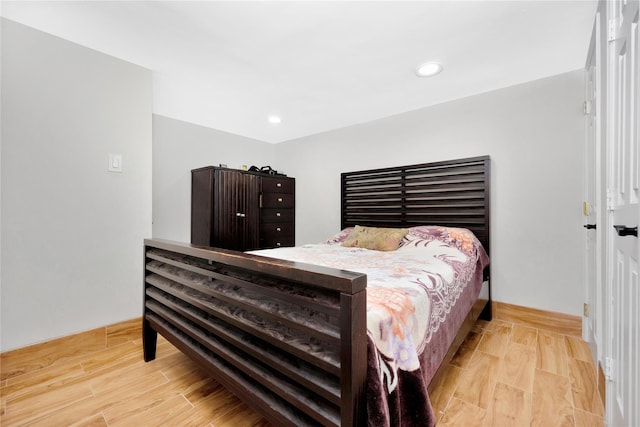 bedroom with recessed lighting and wood finished floors