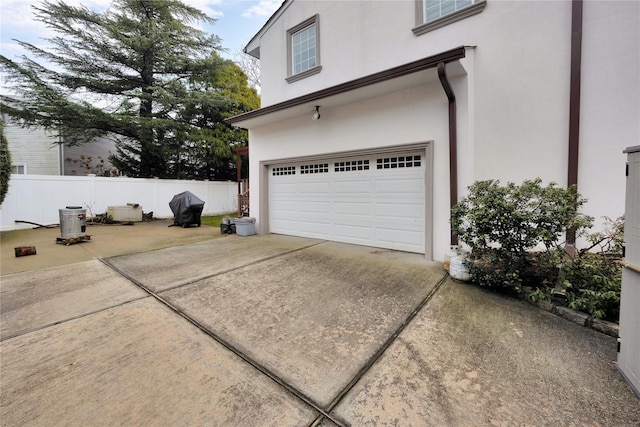 garage featuring fence and driveway