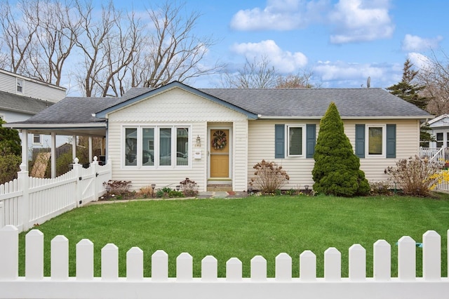 view of front of home with a carport, roof with shingles, fence, and a front lawn