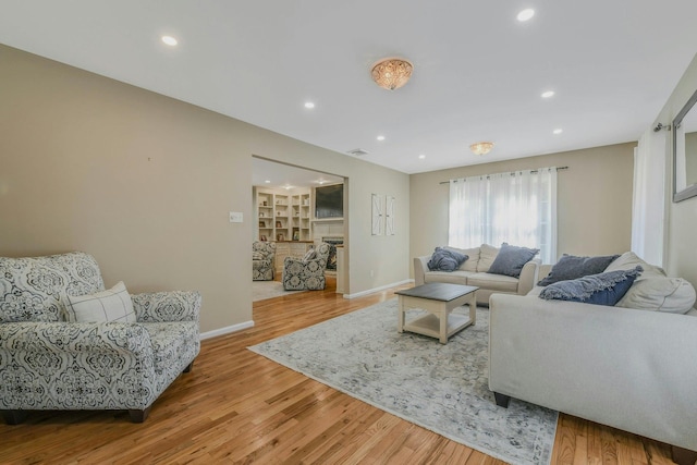 living area featuring recessed lighting, baseboards, and wood finished floors