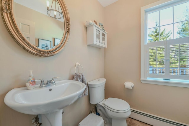 half bathroom with a sink, toilet, tile patterned flooring, and a baseboard radiator