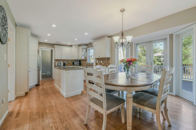 dining room with a healthy amount of sunlight, light wood-style flooring, a chandelier, and recessed lighting