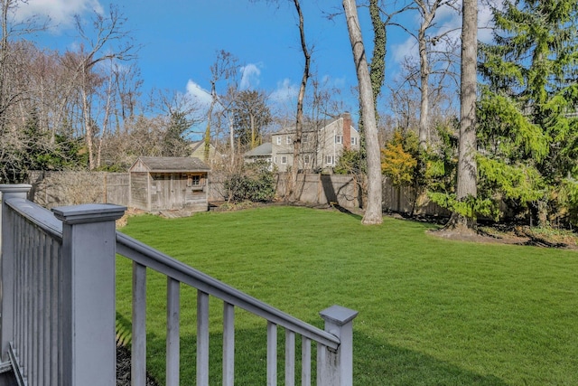 view of yard with an outbuilding, a fenced backyard, and a shed