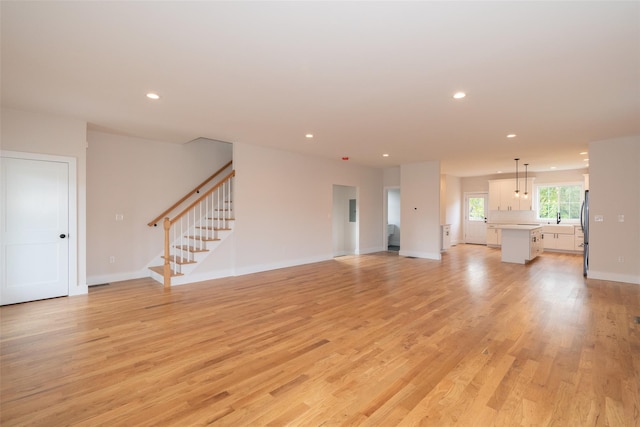 651 Vassar Rd, Poughkeepsie, NY 12603 - unfurnished living room with recessed lighting, light wood-style flooring, baseboards, and stairs