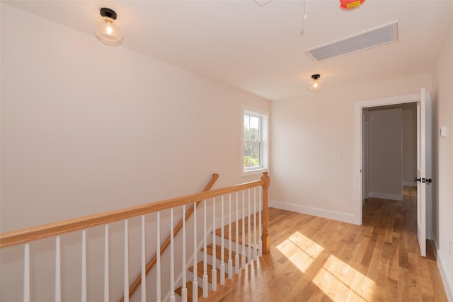 651 Vassar Rd, Poughkeepsie, NY 12603 - corridor with light wood-type flooring, visible vents, baseboards, and an upstairs landing