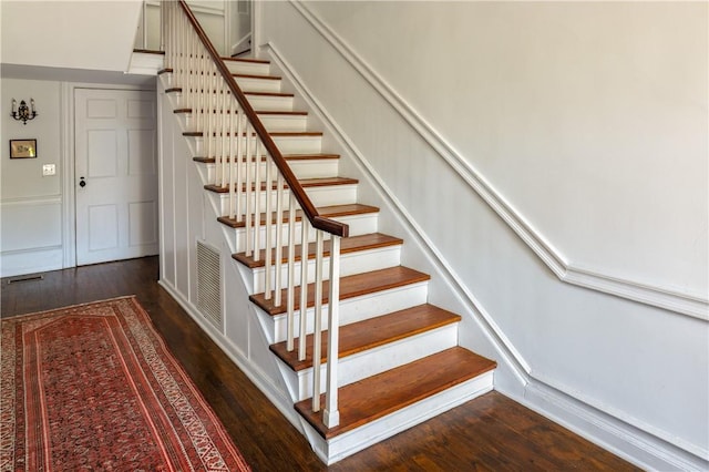 stairs with visible vents and wood finished floors