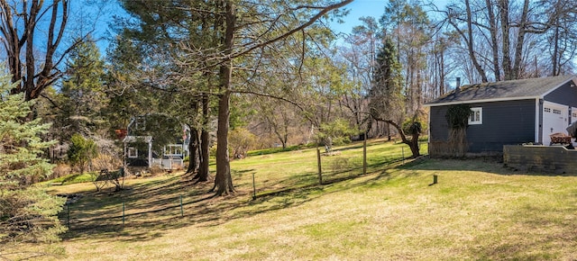 view of yard with fence and an outbuilding