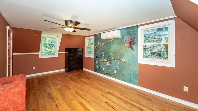 unfurnished room with baseboards, ceiling fan, an AC wall unit, and wood finished floors