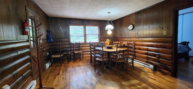 22 Ballard St, Smallwood, NY 12778 - dining room featuring a baseboard radiator, log walls, and wood finished floors