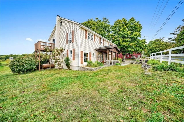view of side of home with a chimney, fence, and a lawn