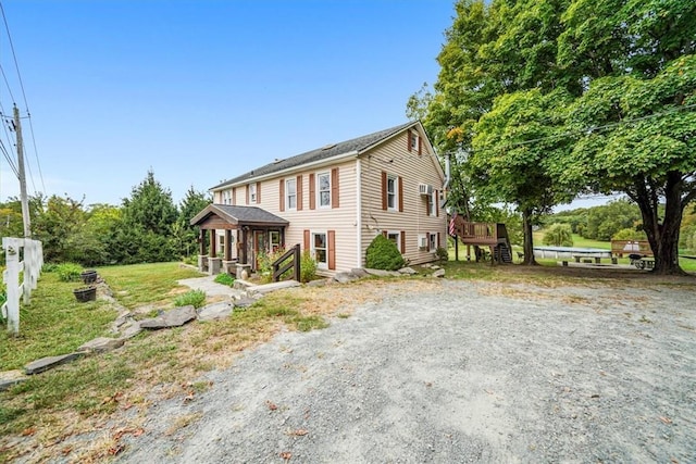 view of front of house with driveway, fence, and a wooden deck