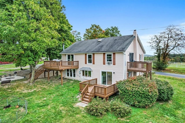 rear view of house with a lawn, a chimney, and a wooden deck