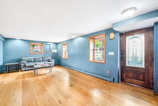 living room with baseboard heating and wood-type flooring