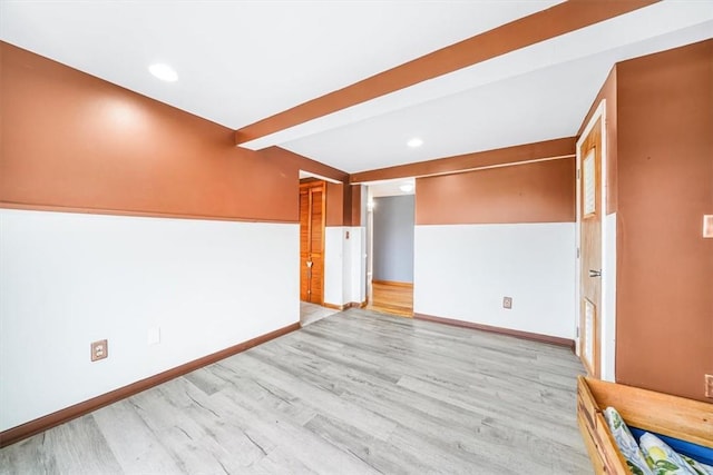 spare room with recessed lighting, baseboards, beamed ceiling, and wood finished floors