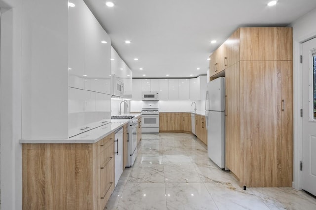kitchen with white appliances, marble finish floor, and modern cabinets