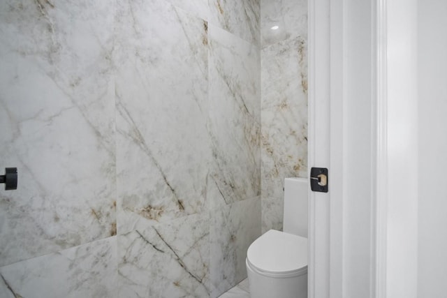 bathroom with marble finish floor and toilet