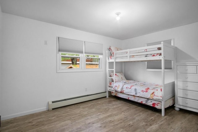 bedroom featuring a baseboard radiator and wood finished floors