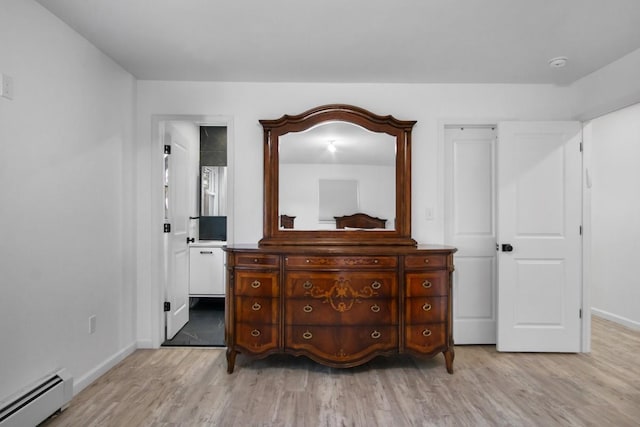 bedroom featuring baseboards, light wood finished floors, and baseboard heating