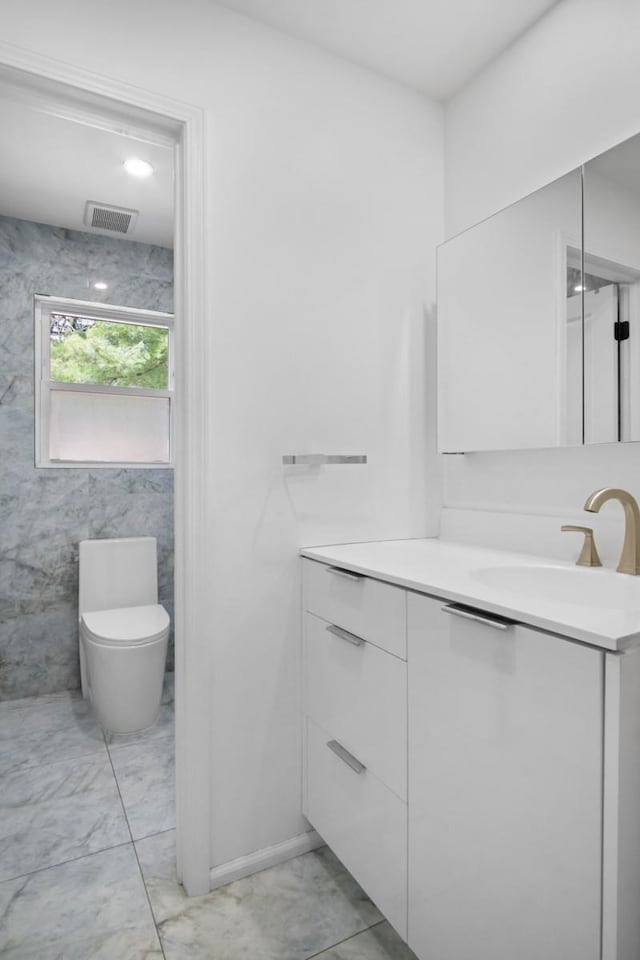 bathroom with visible vents, marble finish floor, vanity, and toilet