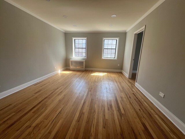 144-32 78th Ave Unit 3F, Flushing, NY 11367 - spare room featuring wood finished floors, baseboards, ornamental molding, and radiator