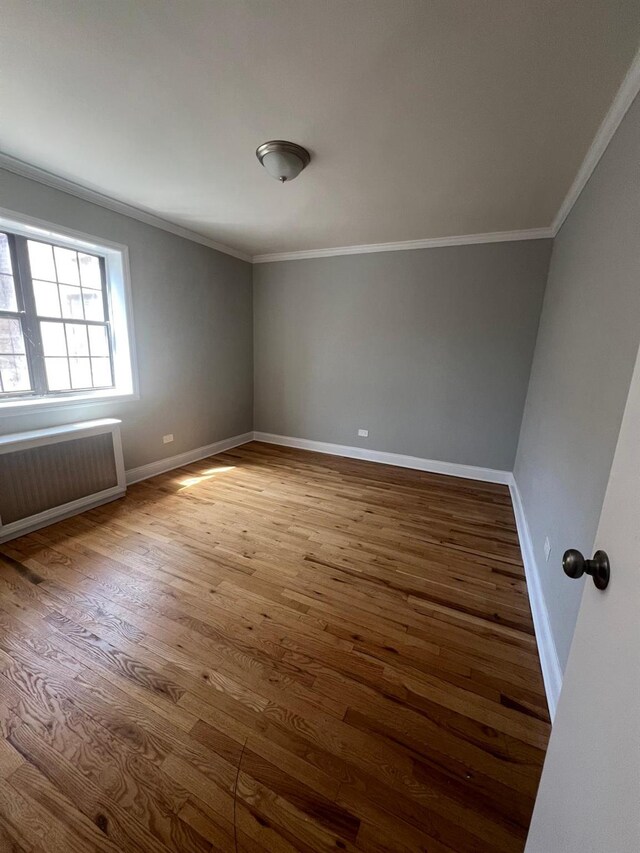 144-32 78th Ave Unit 3F, Flushing, NY 11367 - empty room with ornamental molding, radiator heating unit, wood finished floors, and baseboards