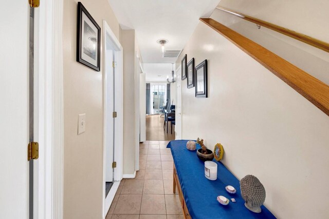 corridor featuring visible vents and light tile patterned floors