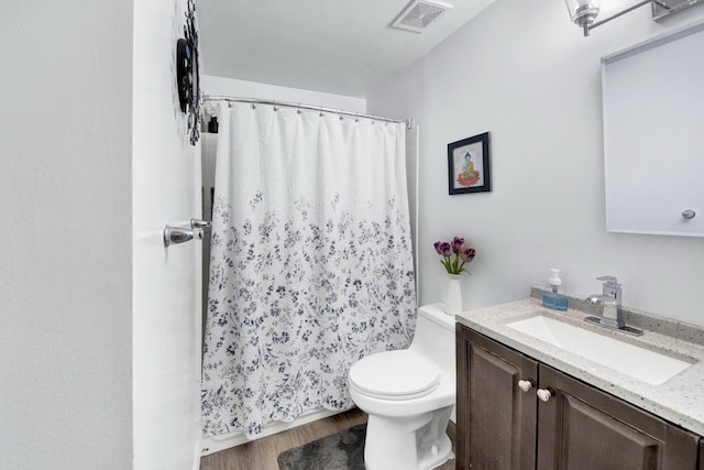 bathroom featuring visible vents, curtained shower, wood finished floors, vanity, and toilet