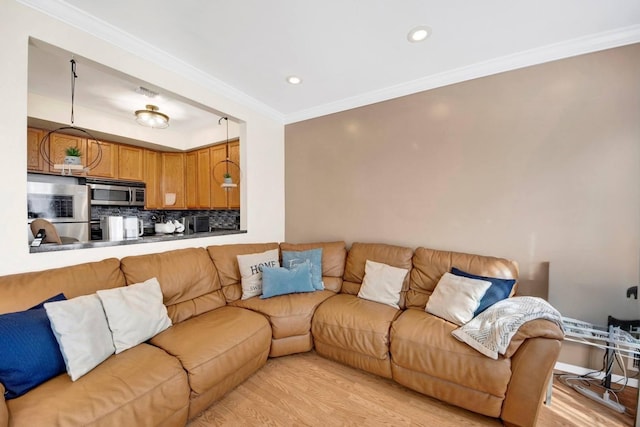 living room featuring light wood-style floors, crown molding, and recessed lighting