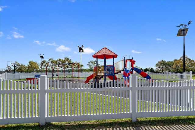 communal playground with fence and a yard