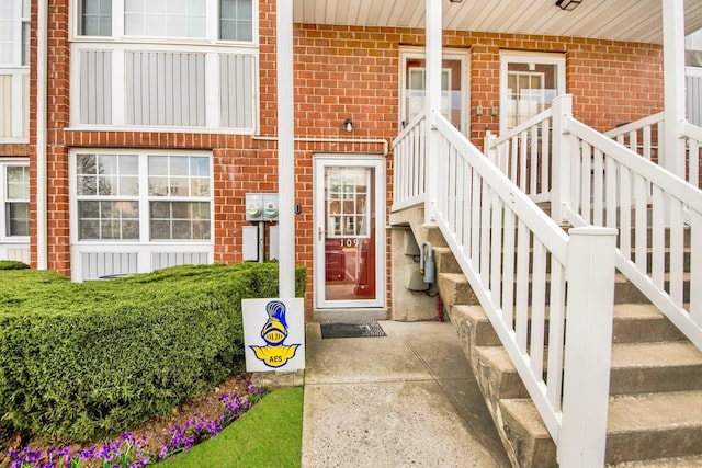 doorway to property featuring brick siding