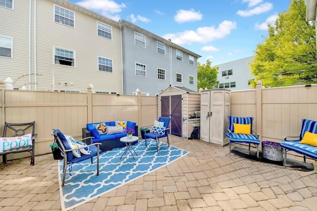 view of patio / terrace featuring an outdoor structure, outdoor lounge area, a shed, and a fenced backyard