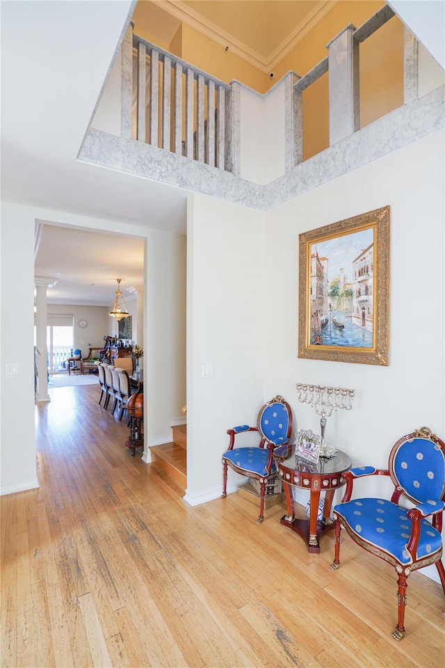 2314 National Dr, Brooklyn, NY 11234 - living area featuring crown molding, hardwood / wood-style floors, decorative columns, baseboards, and a towering ceiling