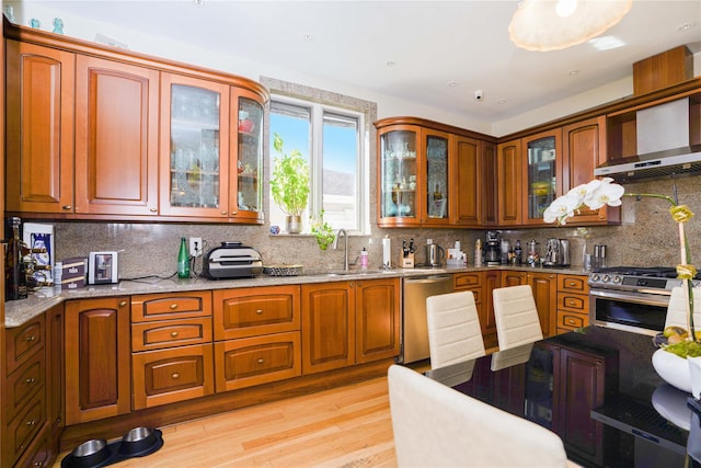 2314 National Dr, Brooklyn, NY 11234 - kitchen featuring stainless steel appliances, tasteful backsplash, a sink, light wood-type flooring, and light stone counters