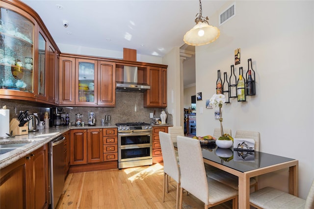 2314 National Dr, Brooklyn, NY 11234 - kitchen with visible vents, wall chimney exhaust hood, stainless steel appliances, tasteful backsplash, and light wood-type flooring