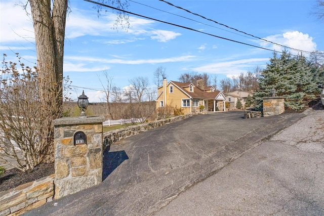 view of front of home with a chimney and driveway
