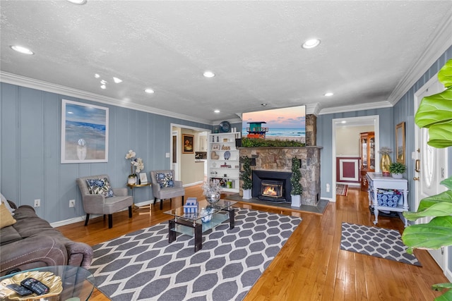living area featuring hardwood / wood-style floors, ornamental molding, and a textured ceiling